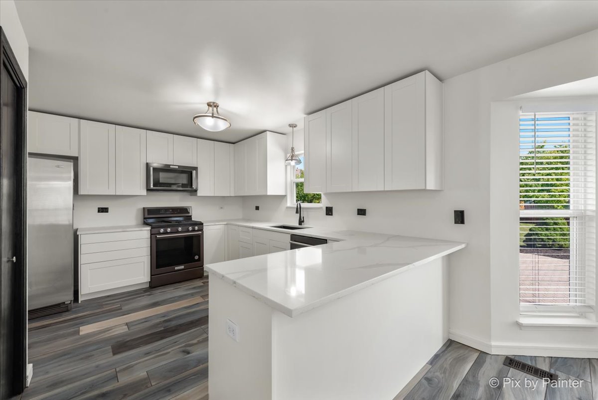1812 Arbor Fields Drive Plainfield, IL 60586 - Photo 5 of 35 a kitchen with a sink a stove a refrigerator and white cabinets