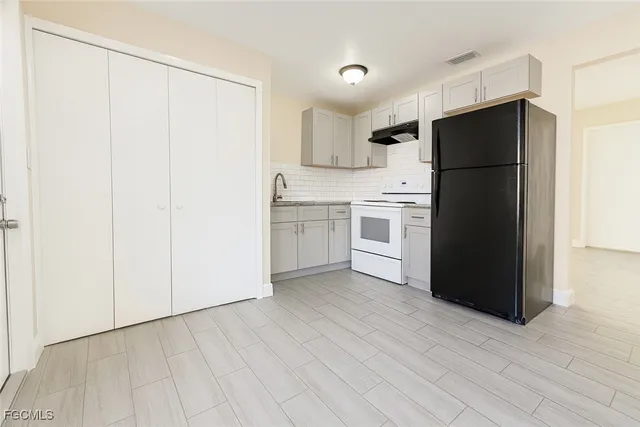 a kitchen with a refrigerator and a stove top oven