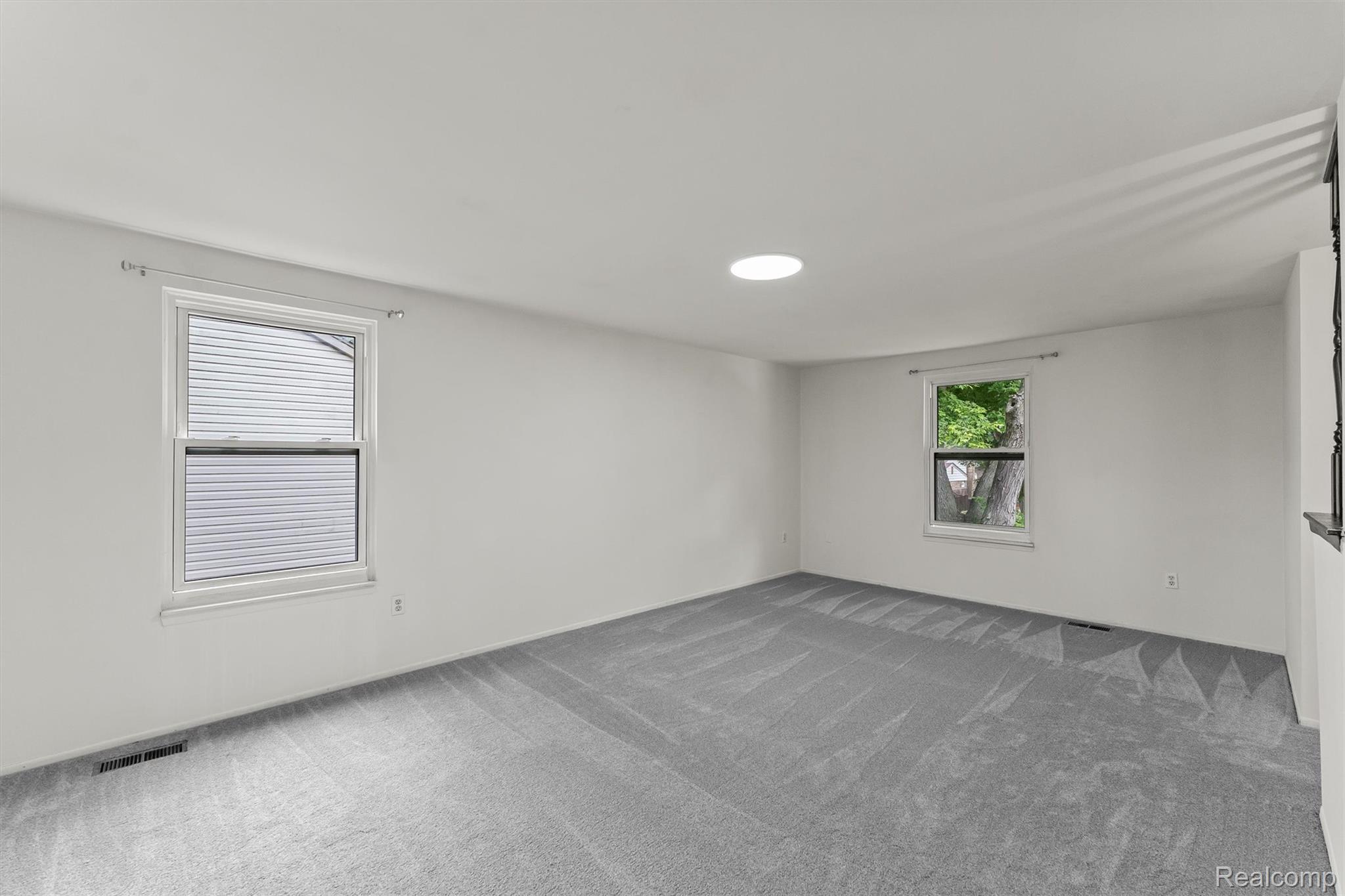 2118 Rutgers Drive Troy, MI 48085 - Photo 20 of 39 Spacious room featuring light gray carpeting, neutral wall finishes, and a circular ceiling light fixture