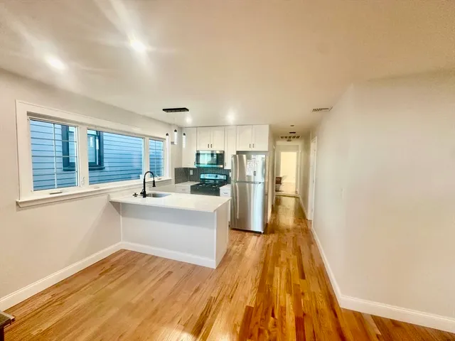 a view of kitchen with wooden floor and electronic appliances