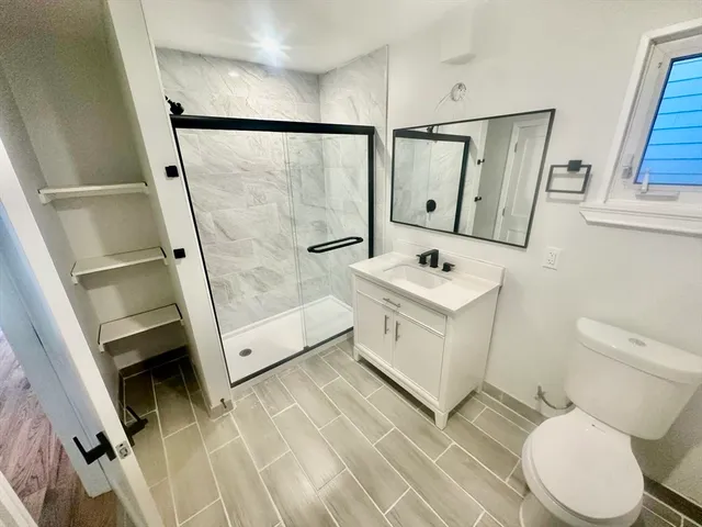 a bathroom with a sink a toilet and shower