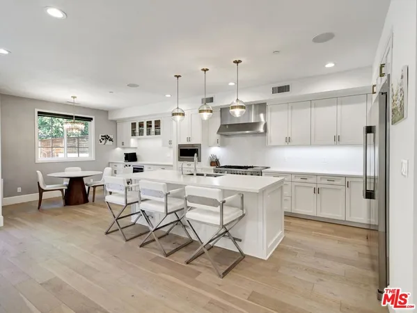 a kitchen with stainless steel appliances kitchen island granite countertop a sink and cabinets