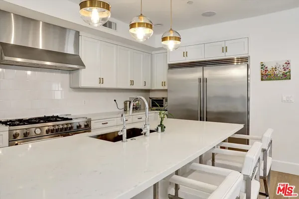 a kitchen with kitchen island a stove a sink and a refrigerator