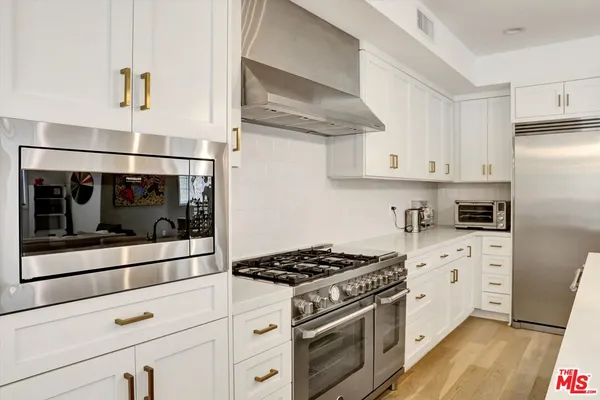 a kitchen with stainless steel appliances granite countertop a sink and a refrigerator