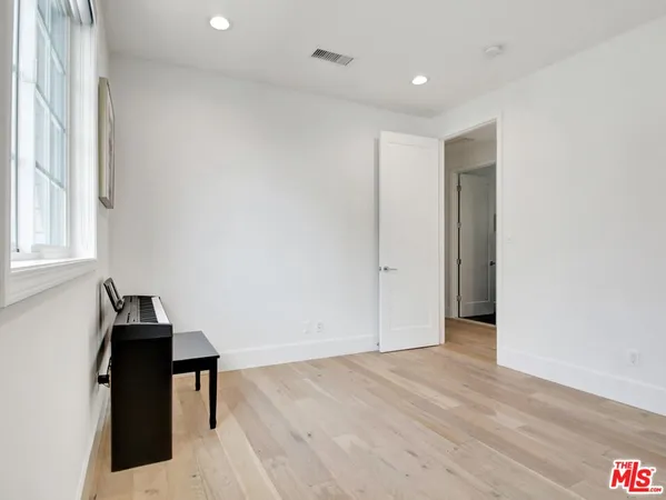 a bedroom with a large bed and a wooden floor