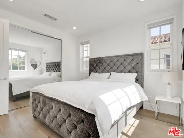 a bedroom with a bed and a large mirror