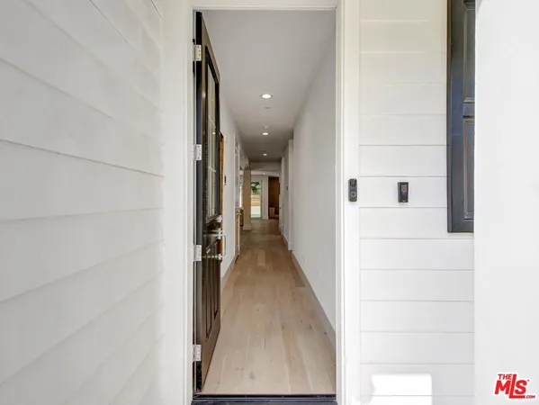 a view of a hallway with wooden floor and staircase