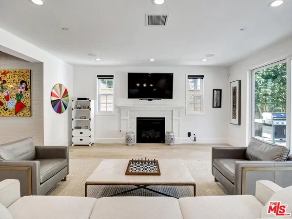 a living room with furniture a flat screen tv and a fireplace