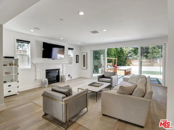 a living room with furniture a flat screen tv and a fireplace