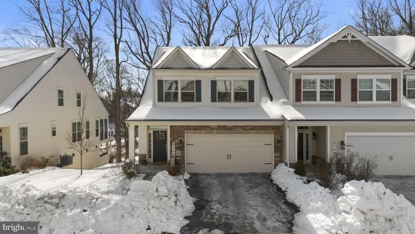 a front view of a house with a yard covered in snow