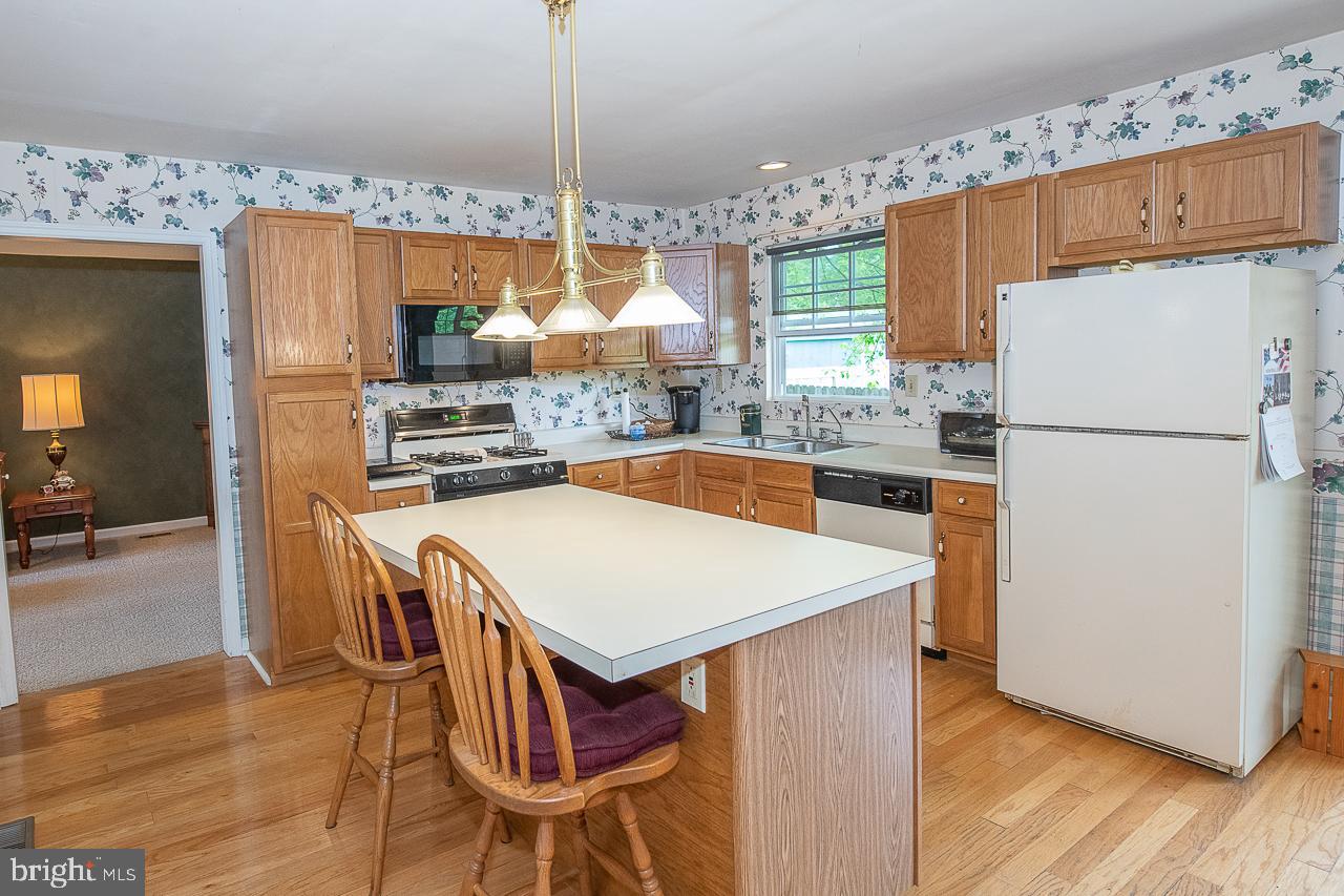 527 Schick Road Aston, PA 19014 - Photo 12 of 28 a kitchen with a table chairs refrigerator and window