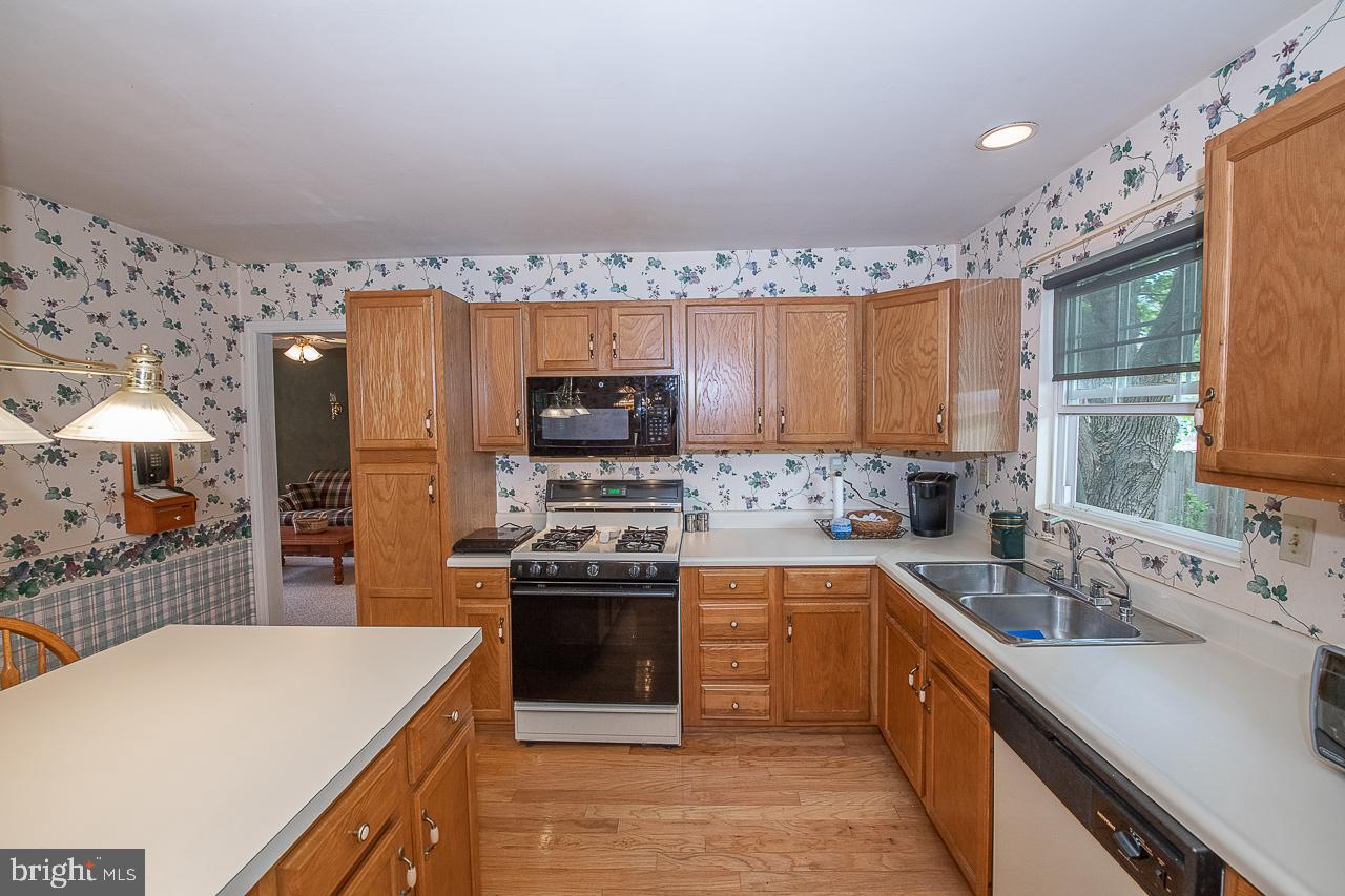 527 Schick Road Aston, PA 19014 - Photo 13 of 28 a kitchen with a sink a stove and cabinets