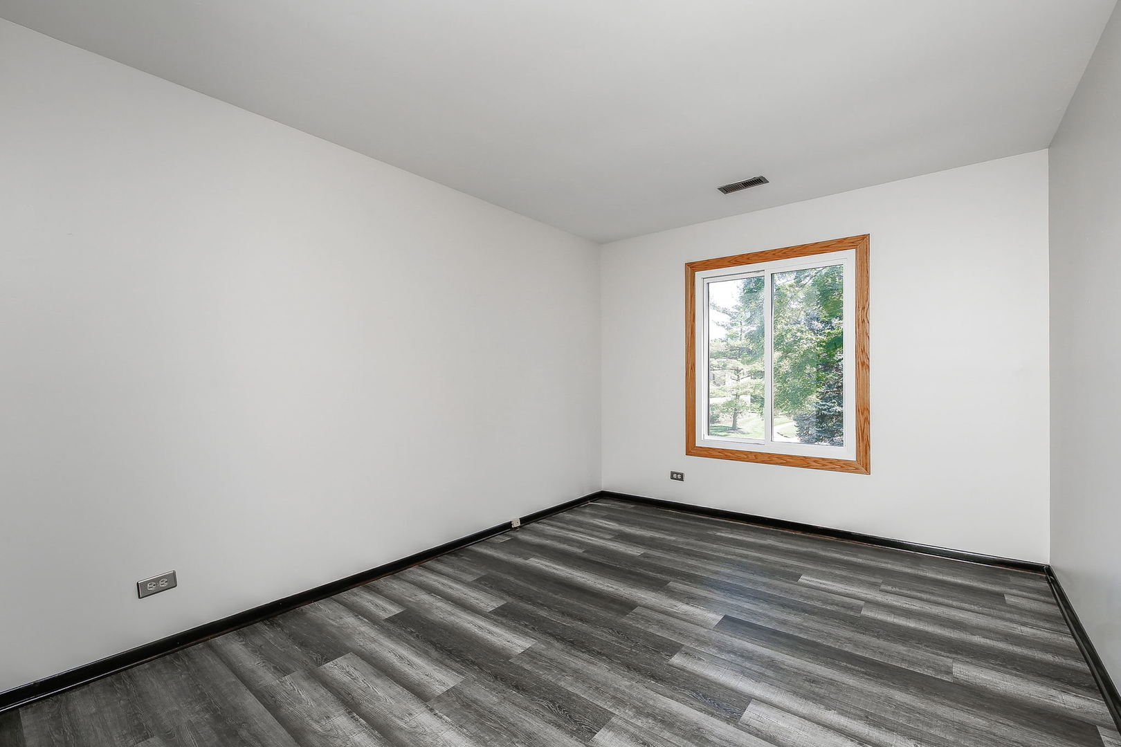 865 Sheldon Court, Unit C Wheaton, IL 60189 - Photo 10 of 17 a view of an empty room with wooden floor and a window