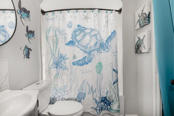 a white toilet sitting next to a shower curtain