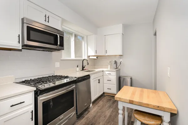 a kitchen with stainless steel appliances a stove microwave and sink