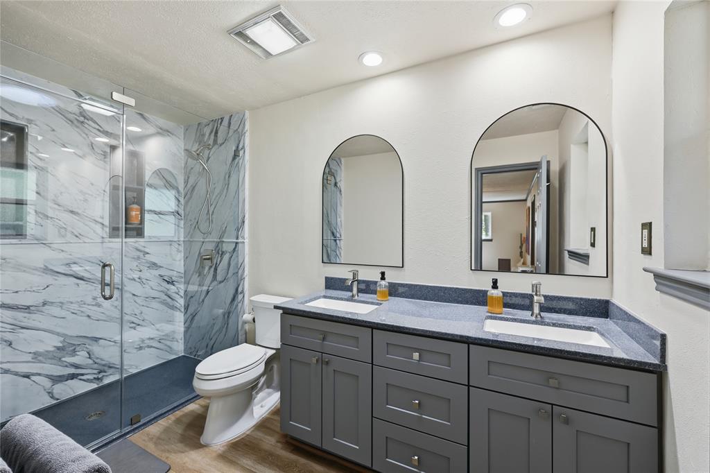 4000 Post Oak Road Flower Mound, TX 75022 - Photo 16 of 40 Main house - Full primary bathroom featuring double sinks, dark wood style floors, and a renovated shower with opposing showerheads