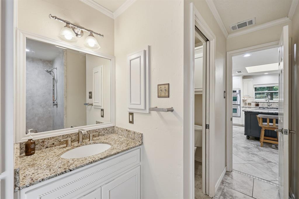 4000 Post Oak Road Flower Mound, TX 75022 - Photo 19 of 40 Main house - Full bathroom featuring crown molding, vanity, and exit door to the rear of the house for easy rinsing off after swimming