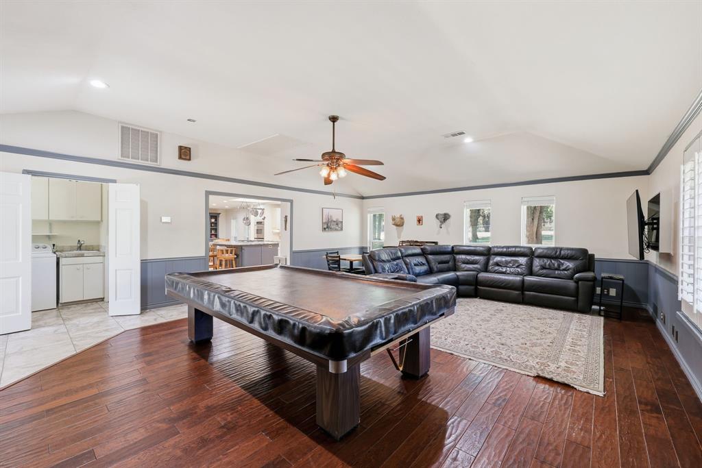 4000 Post Oak Road Flower Mound, TX 75022 - Photo 20 of 40 Main house - Recreation room featuring vaulted ceiling, billiards table, a wainscoted wall, ornamental molding, and easy access to the rear of the property. The tournament size billiard table stays as a bonus!