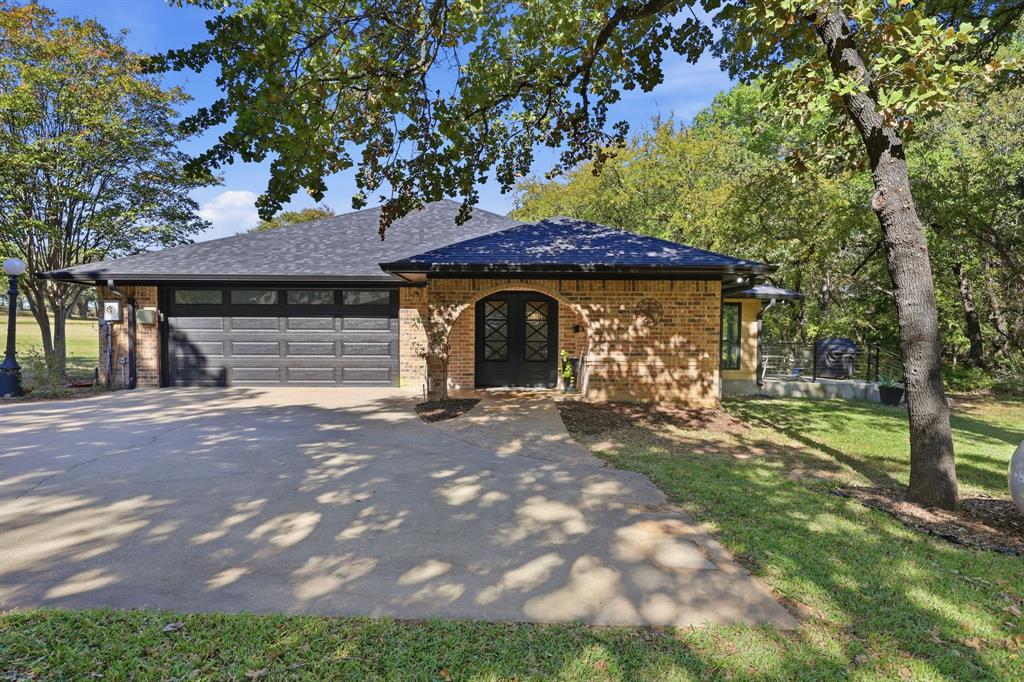 4000 Post Oak Road Flower Mound, TX 75022 - Photo 23 of 40 Guest House - View of front of the guest house featuring driveway, brick, an attached garage, and patio off the dining room. This home has 2 bedrooms, 1.5 bathrooms, and a finished and air conditioned study off of the garage.