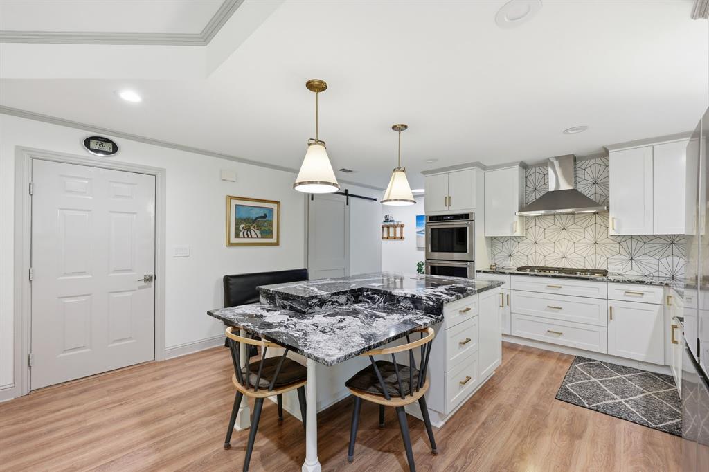 4000 Post Oak Road Flower Mound, TX 75022 - Photo 27 of 40 Guest house - Kitchen with dark stone countertops, decorative backsplash, a center island, crown molding, double ovens, pantry with barn door, and reverse osmosis under the sink