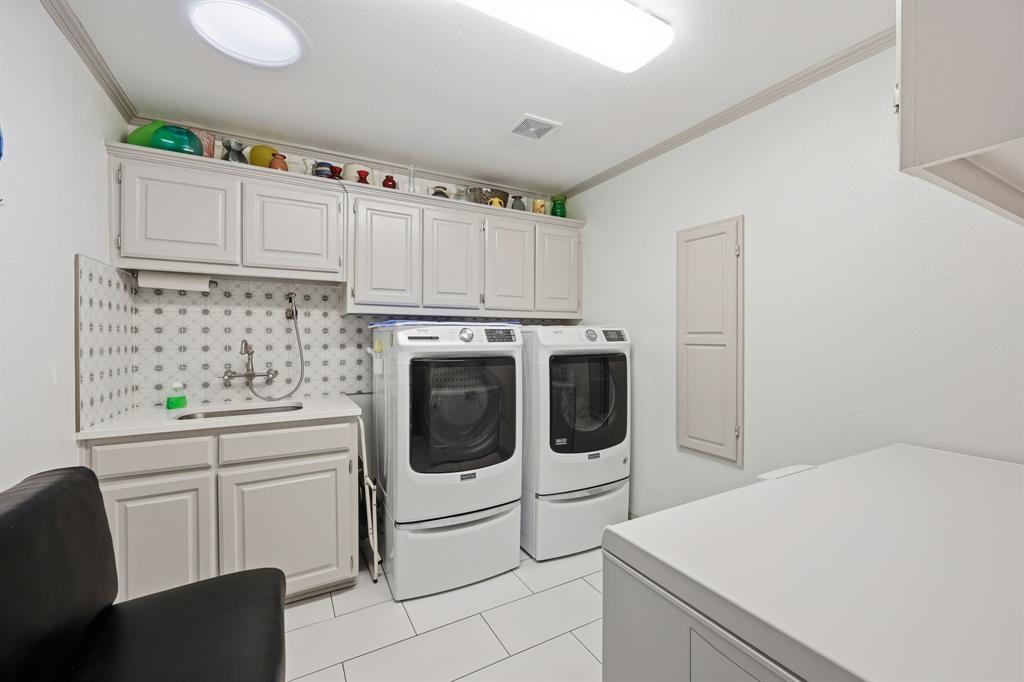 4000 Post Oak Road Flower Mound, TX 75022 - Photo 29 of 40 Guest house - Laundry room featuring crown molding, cabinets, sink with sprayer, space for a second freezer or refrigerator, and skylight