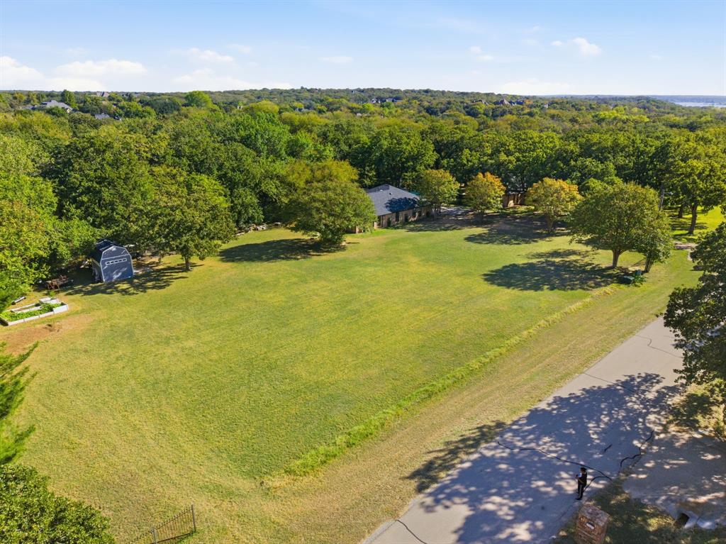 4000 Post Oak Road Flower Mound, TX 75022 - Photo 35 of 40 Overview of the cleared front lawn, with irrigated garden and sheds off to the left and the guest house visible through the trees
