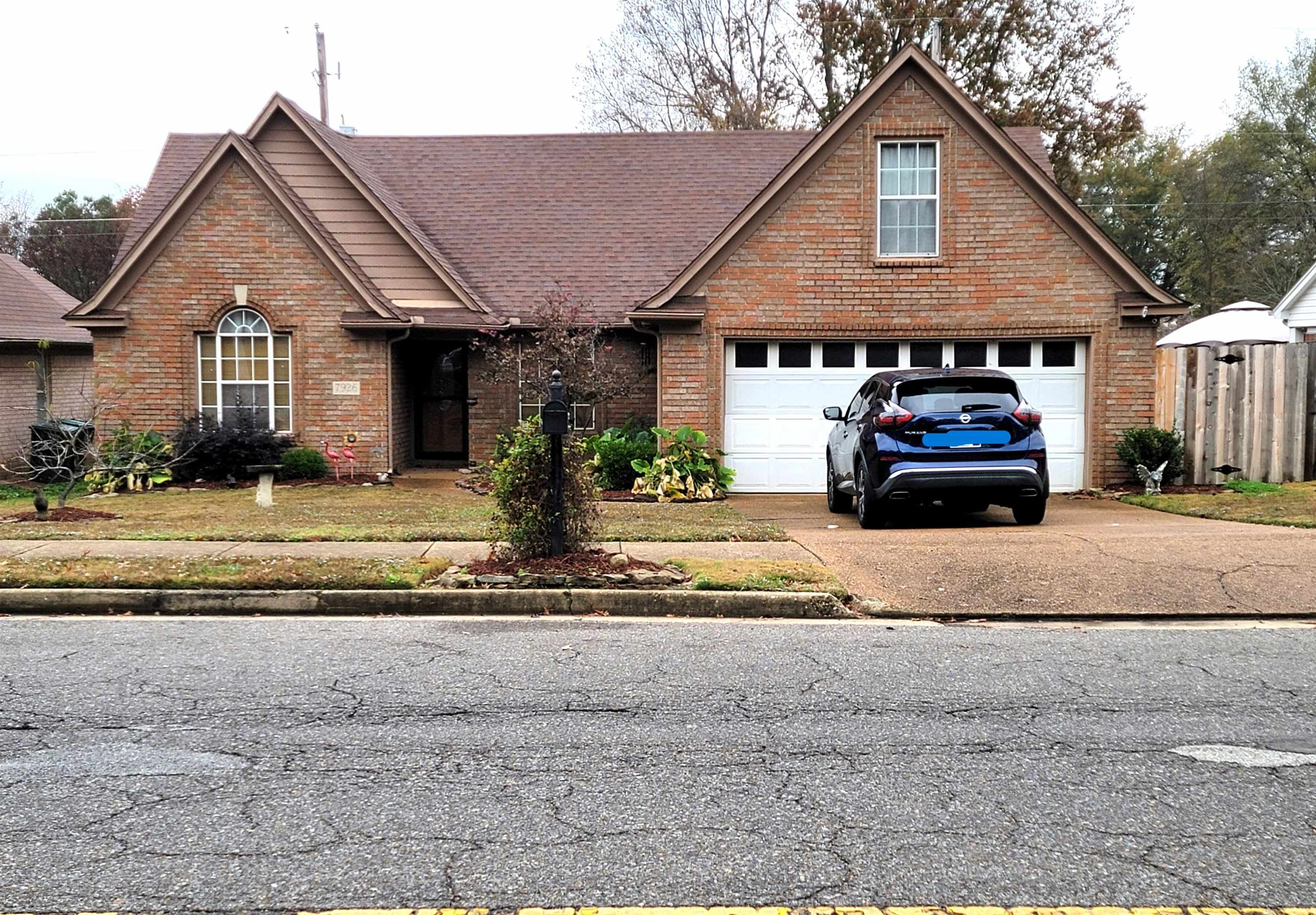 7926 Macon Road Cordova, TN 38018 - Photo 1 of 15 Traditional-style house with brick siding, driveway, a garage, and roof with shingles