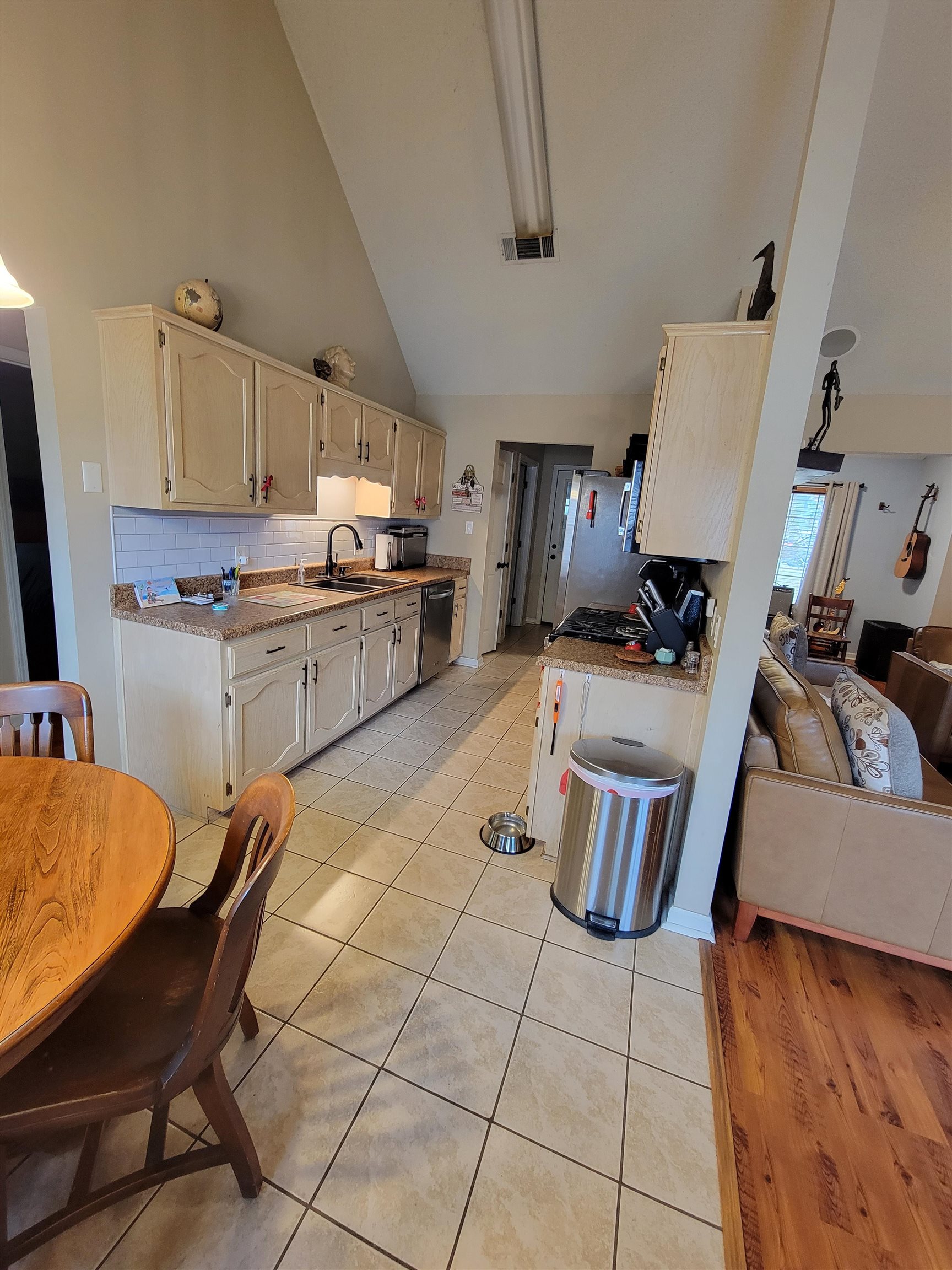 7926 Macon Road Cordova, TN 38018 - Photo 11 of 15 Kitchen featuring backsplash, light tile patterned floors, high vaulted ceiling, and dishwasher