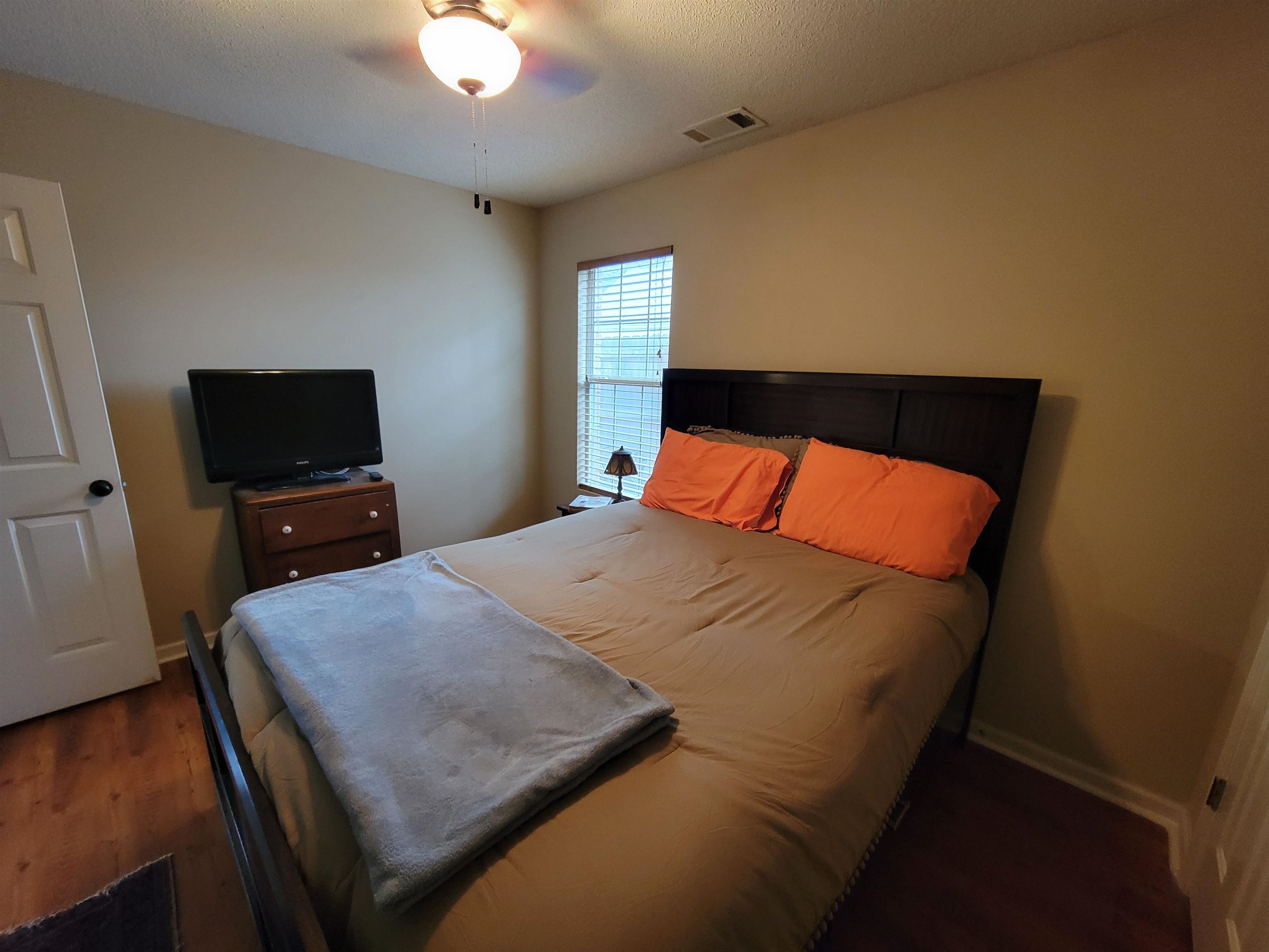 7926 Macon Road Cordova, TN 38018 - Photo 7 of 15 Bedroom featuring a ceiling fan, dark wood-style flooring, and a textured ceiling