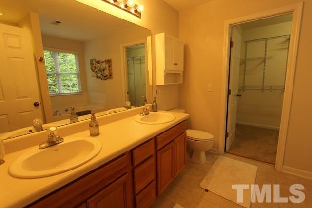 9914 Reanne Court Raleigh, NC 27617 - Photo 14 of 25 a bathroom with a double vanity sink toilet mirror and shower