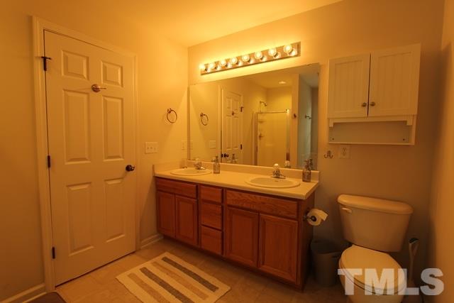 9914 Reanne Court Raleigh, NC 27617 - Photo 16 of 25 a bathroom with a toilet a sink and mirror