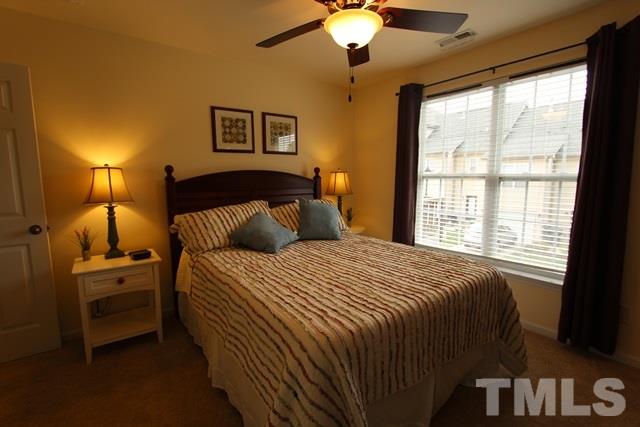9914 Reanne Court Raleigh, NC 27617 - Photo 17 of 25 a bedroom with a bed and a chandelier