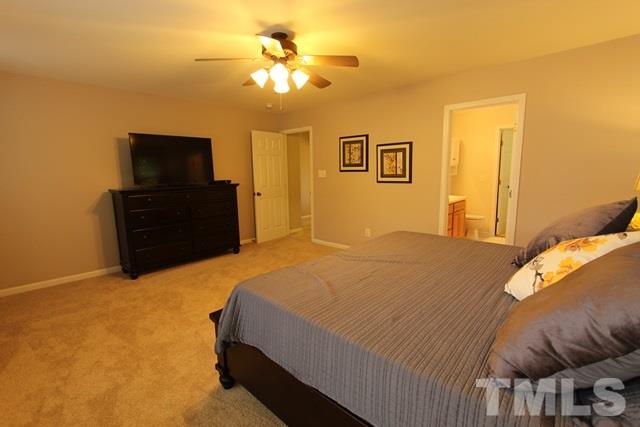 9914 Reanne Court Raleigh, NC 27617 - Photo 19 of 25 a bedroom with a bed and a chandelier
