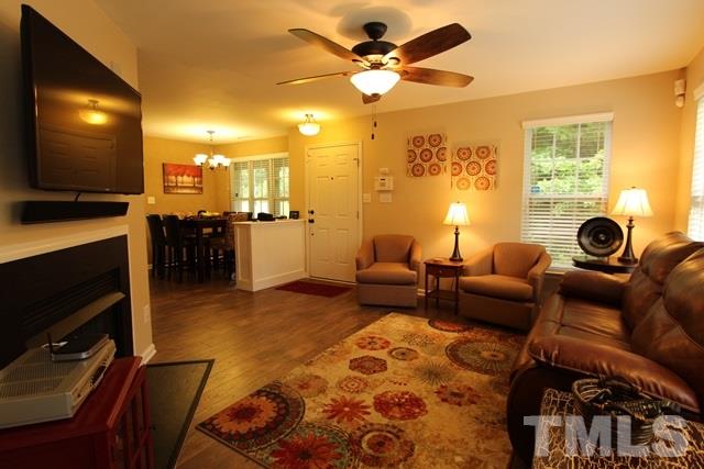 9914 Reanne Court Raleigh, NC 27617 - Photo 5 of 25 a living room with furniture a flat screen tv and a fireplace