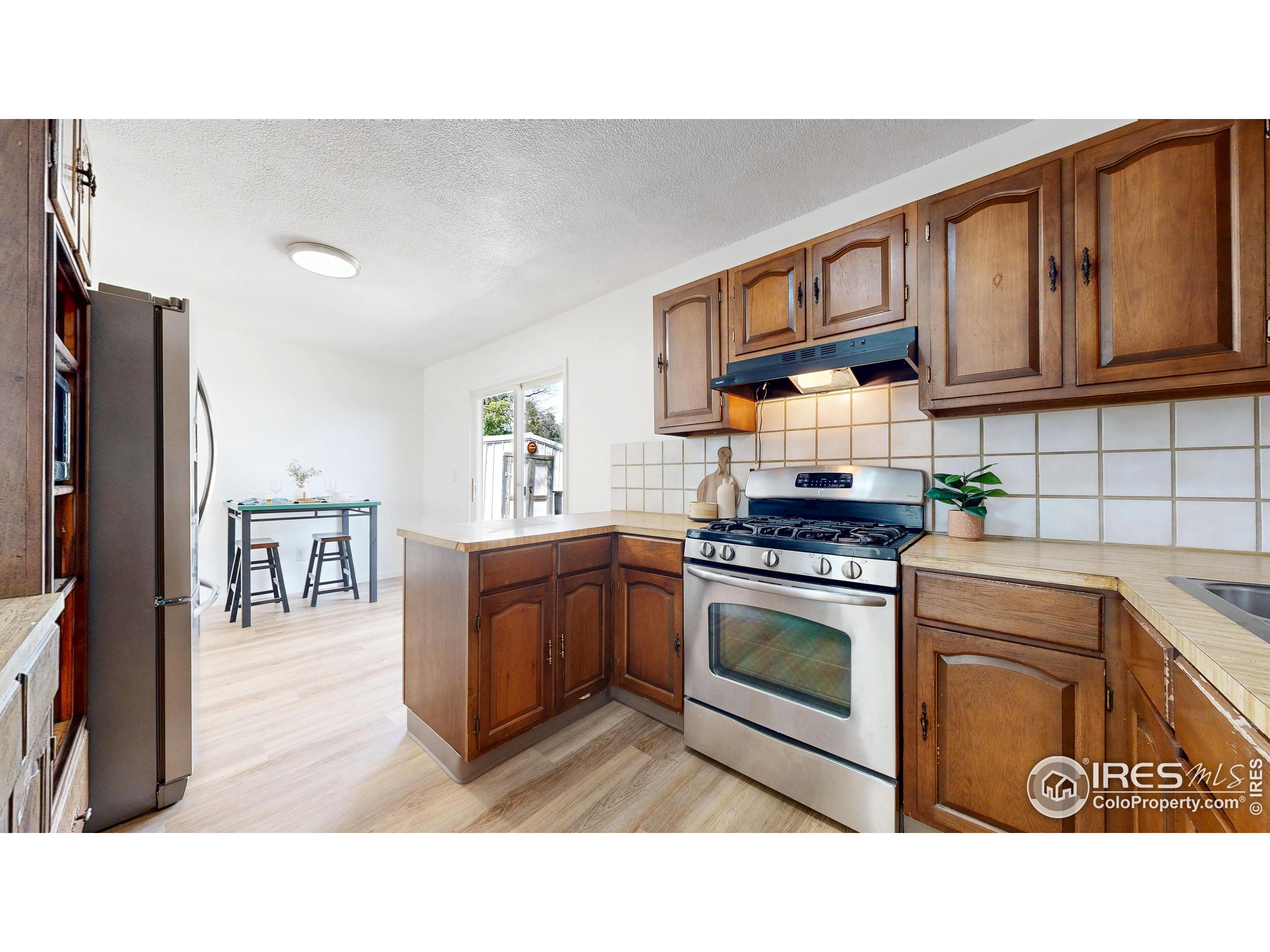 117 Fry Street Ault, CO 80610 - Photo 12 of 39 a kitchen with stainless steel appliances granite countertop a stove a sink dishwasher and a refrigerator