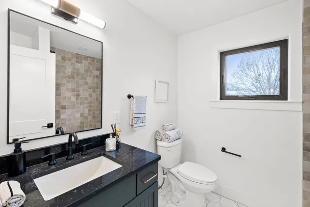 a bathroom with a toilet a sink and mirror