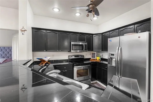 a kitchen with a refrigerator a microwave a sink and cabinets