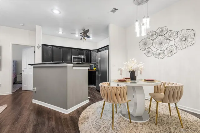 a kitchen with kitchen island a stove a table and chairs in it