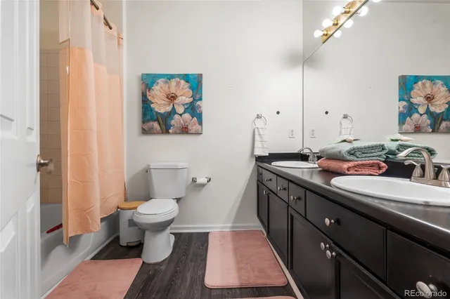 a bathroom with a granite countertop sink a large mirror a toilet and a shower