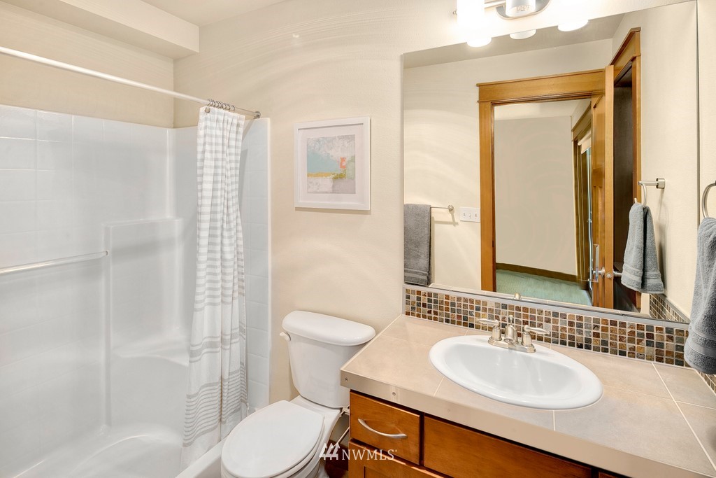 1717 18th Avenue, Unit B Seattle, WA 98122 - Photo 13 of 25 a bathroom with a toilet sink a mirror and shower