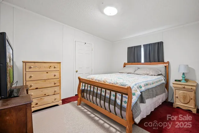 a bedroom with a bed and a television