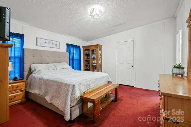 a bed sitting in a bedroom and night stand