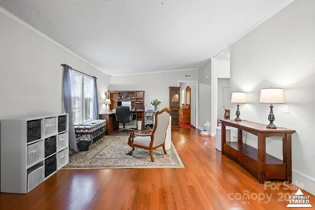 a living room with furniture a window and wooden floor