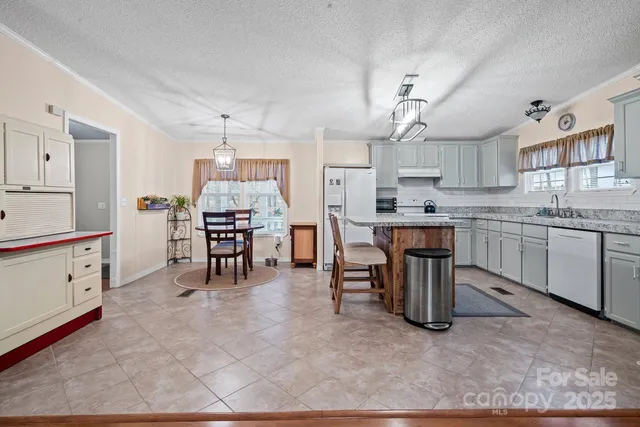 a kitchen with a table chairs refrigerator and cabinets