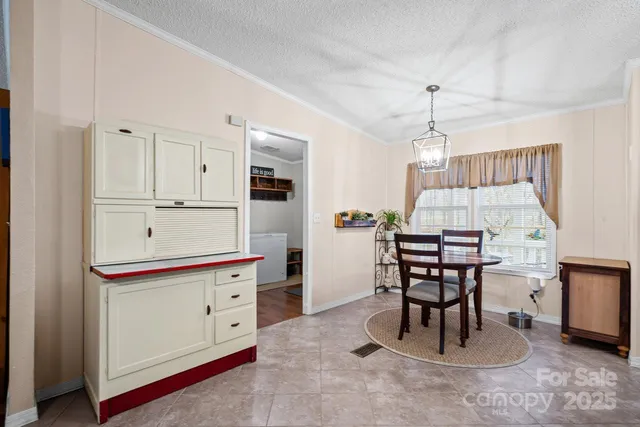 a kitchen with a table chairs and white cabinets