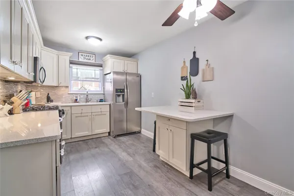 a kitchen with refrigerator cabinets and wooden floor