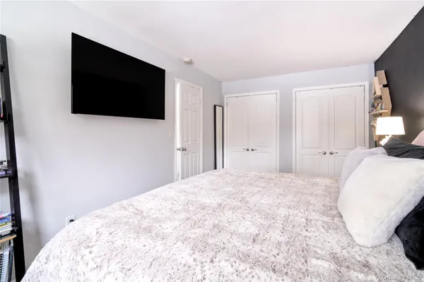 a bedroom with a bed and a flat screen tv