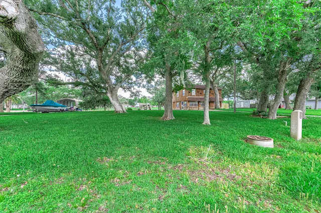 a view of a house with a big yard and large trees
