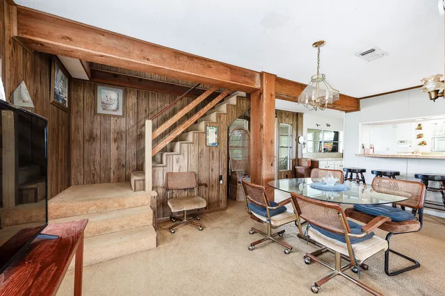 a dining room with wooden floor and a chandelier