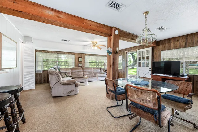 a living room with patio furniture and a flat screen tv